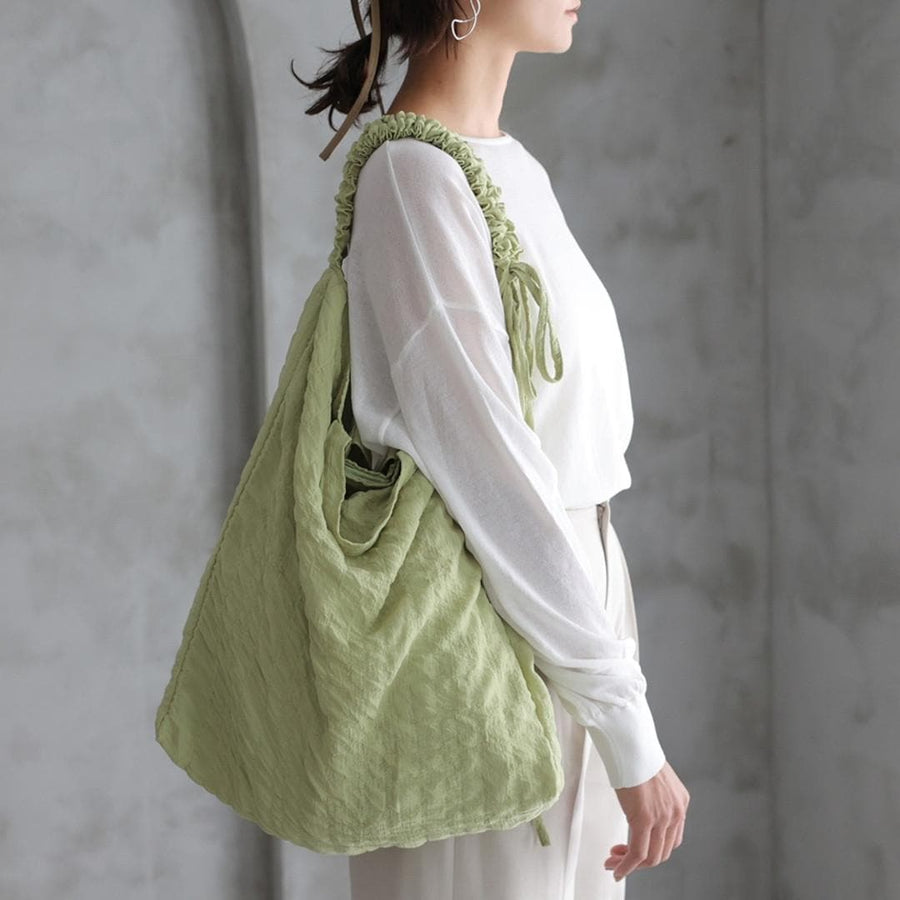A crumpled drawstring gathered handle bag