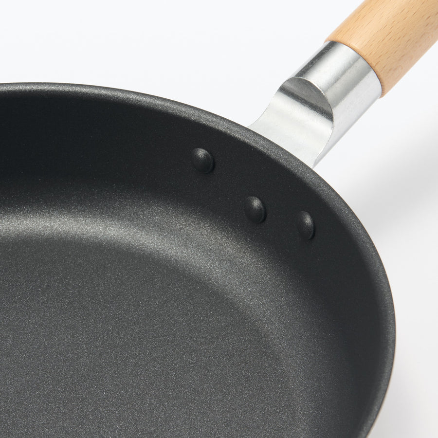 A shallow frying pan with a large cooking surface and low sticking properties
