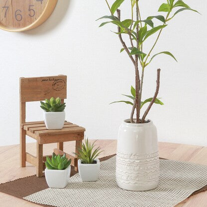 Fake greenery with a beautiful vertical silhouette (Osmanthus fragrans in a ceramic pot)