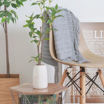 Fake greenery with a beautiful vertical silhouette (Osmanthus fragrans in a ceramic pot)