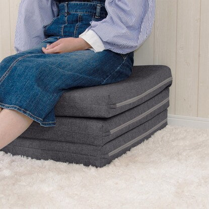 A sleeping mattress that can be used as an ottoman or stool (gray)