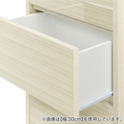 A slim cabinet with a beautiful wood grain pattern and drawers (width 30 x height 85 cm, gloss finish WW)