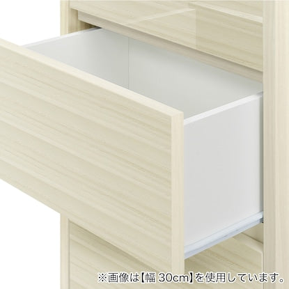 A slim cabinet with a beautiful wood grain pattern and drawers (width 32 x height 85 cm, gloss finish WW)