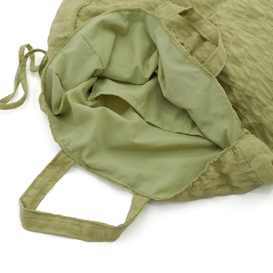 A crumpled drawstring gathered handle bag