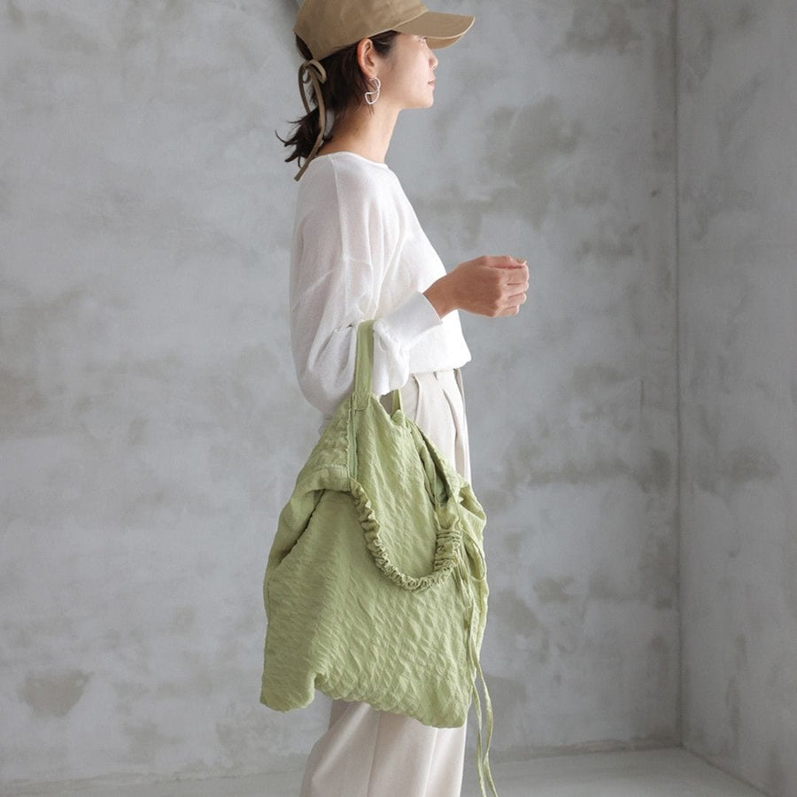 A crumpled drawstring gathered handle bag