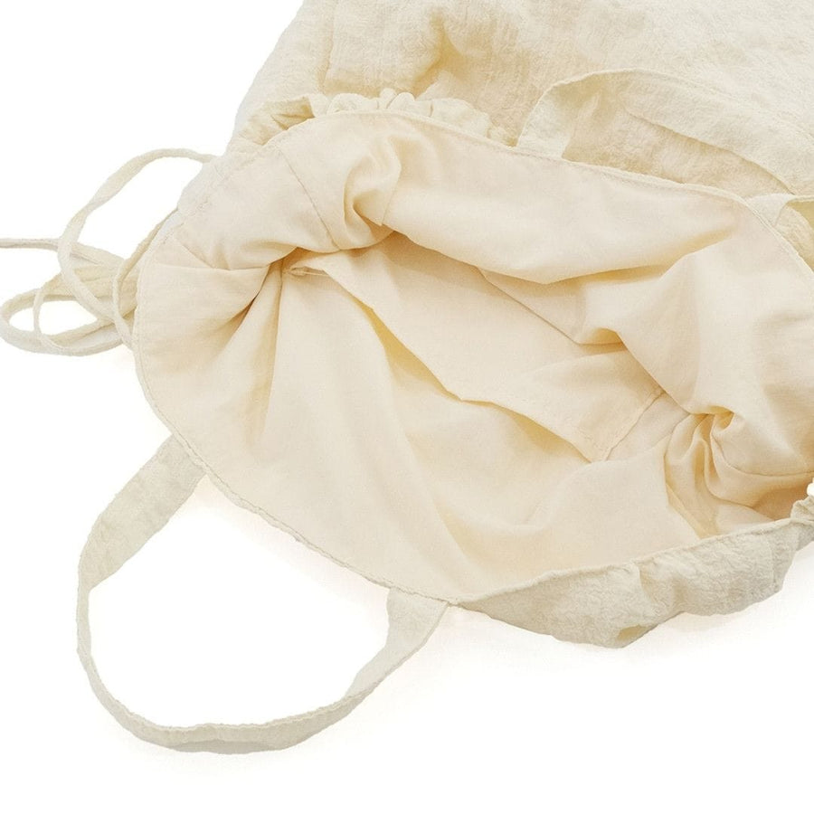 A crumpled drawstring gathered handle bag
