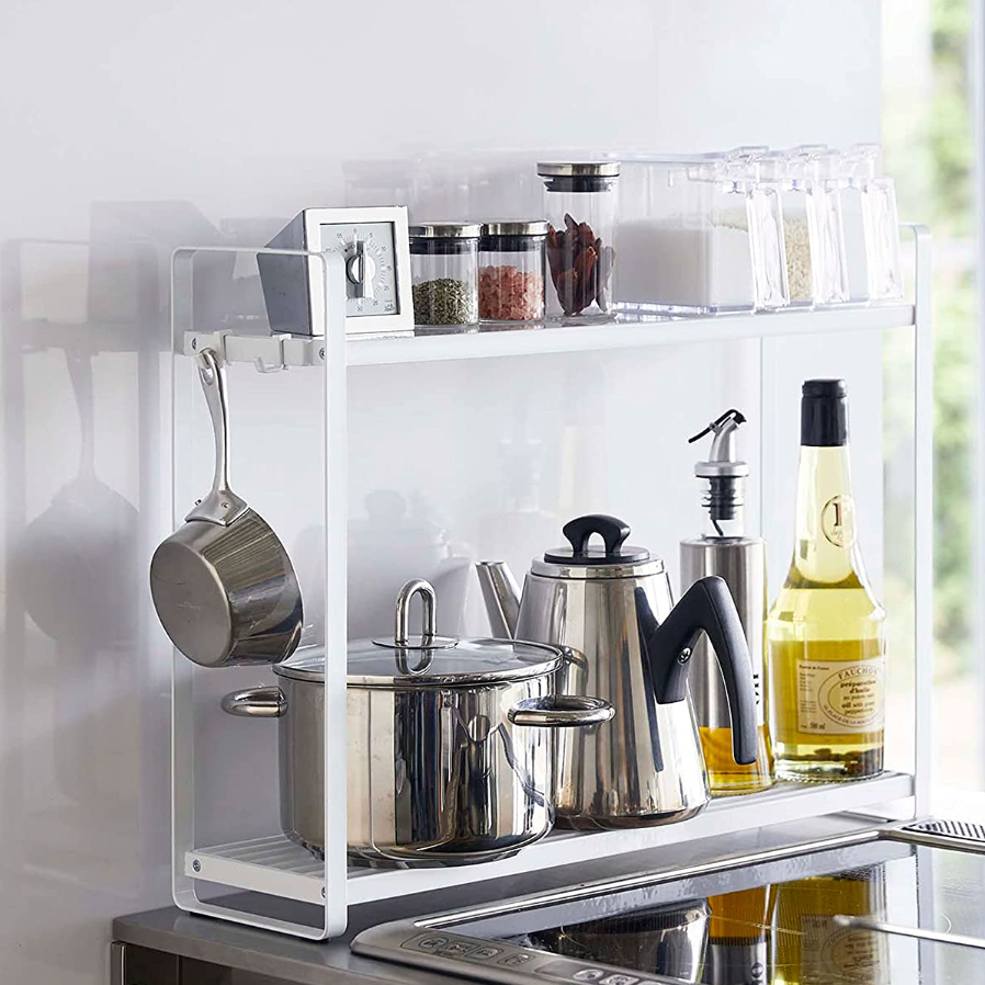 2-tier spice rack next to stove with hooks